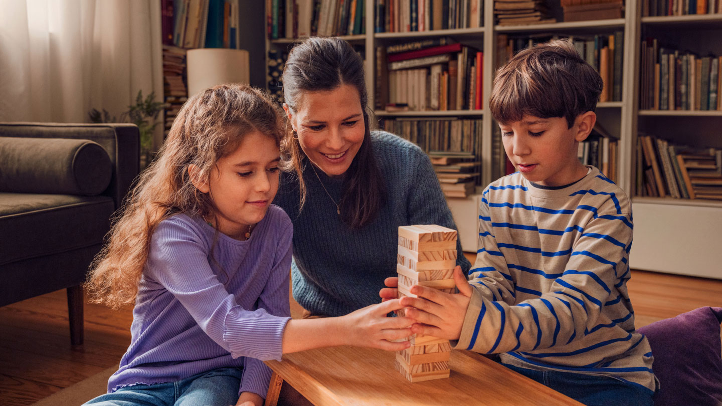 Mutter spielt mit Kindern Jenga Spiel